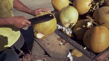 uzak kesmek üstünde onun balta ile taze Hindistan cevizi Hindistan cevizi sokak satıcısı