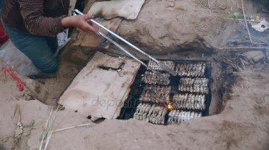 İn-yer Barbekü ızgara ve pişirme maşa kullanarak balık (yakın )