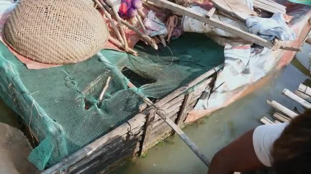 Cerca de un piscicultor alimentando peces en una caja de bambú fijada a una casa flotante — Vídeo de stock