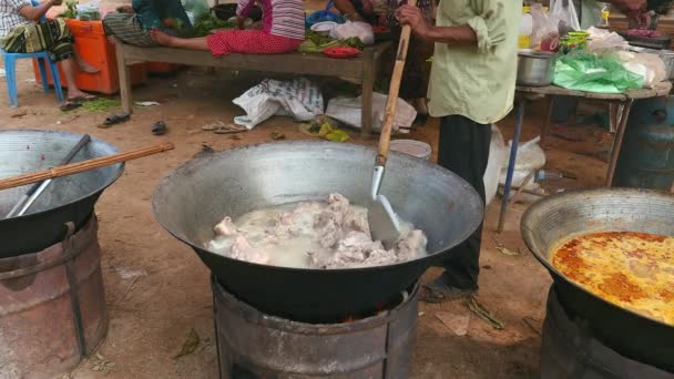 Pork Chops Boiling In A Large Pot Over Makeshift Fire Pit Stock