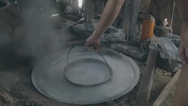 Mann blanchiert Reisteig in einem ausgehöhlten Eimer mit kochendem Wasser — Stockvideo