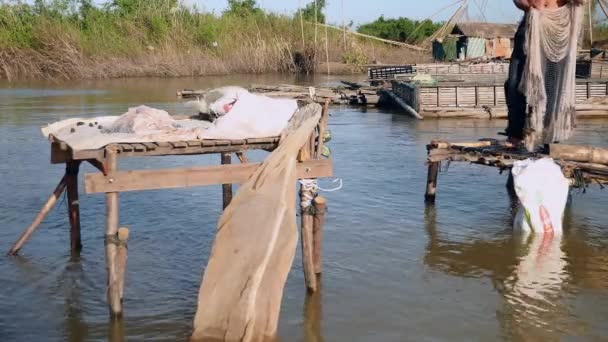 Fiskaren gjutning net i en damm från en liten plattform av trä — Stockvideo