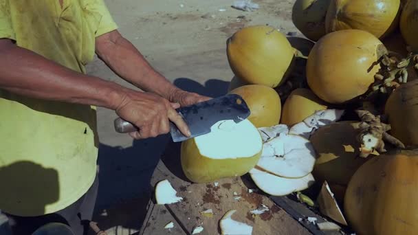 Vendeur de rue de noix de coco préparant une noix de coco potable pour les clients : haut coupé, trou sur le dessus et fente sur le côté avec une paille à travers elle — Video