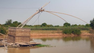 Bambu balık sandık düşük tide nehirde çıkan; Ev Çince balık ağı arkasında ile tekne (yakın )