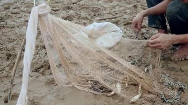 Enmeshed balık onun net kaldırma ve bir plastik torba içinde tutarak balıkçı
