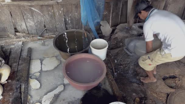 Человек тесто риса в дырявом ведре с кипящей водой — стоковое видео
