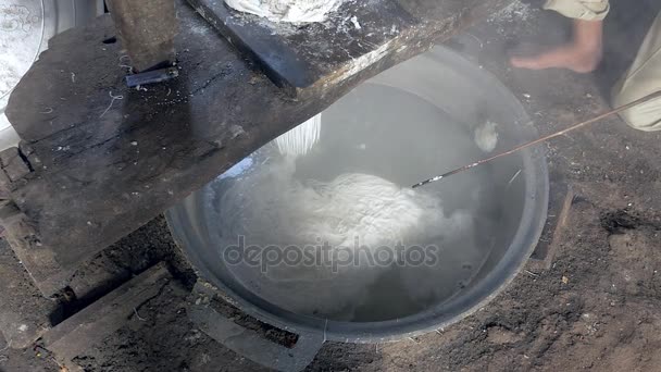 Чоловік натискає рисове тісто; рисова локшина готується в киплячій воді — стокове відео