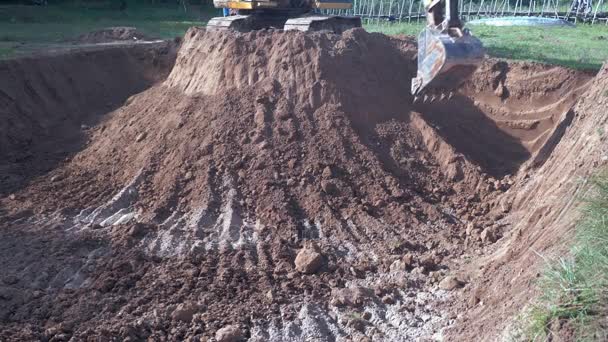 Excavadora excavando tierra en el sitio — Vídeos de Stock