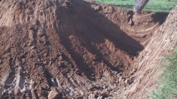 Primer plano de una excavadora excavando tierra en el sitio — Vídeos de Stock