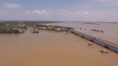 kent içi su dolu nehri geçip çalıştıran bir beton köprü doğru uçan