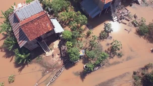 Aéreo: sobrevoar duas famílias que caminham através do quintal inundado que conduz a suas casas rurais — Vídeo de Stock