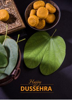 tebrik kartı mutlu vijayadashmi veya mutlu dussehra, hint festivali dussehra, gümüş kase geleneksel hint tatlılar pedha ile apta yaprağı veya Bauhinia racemosa gösteren söyleyerek