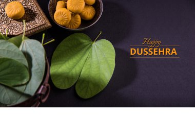 tebrik kartı mutlu vijayadashmi veya mutlu dussehra, hint festivali dussehra, gümüş kase geleneksel hint tatlılar pedha ile apta yaprağı veya Bauhinia racemosa gösteren söyleyerek