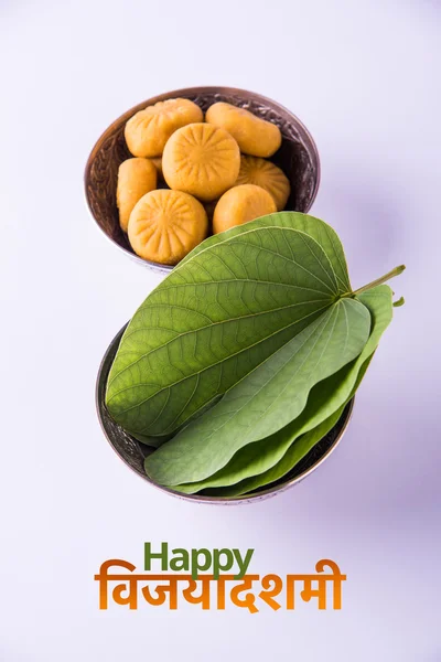 Üdvözlőlap mondván boldog Vijayadashmi vagy boldog Dussehra, indiai fesztivál Dussehra, bemutatva ApTa levél vagy Bauhinia racemosa hagyományos indiai édességek pedha az ezüst tálba — Stock Fotó