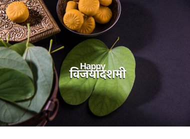 tebrik kartı mutlu vijayadashmi veya mutlu dussehra, hint festivali dussehra, gümüş kase geleneksel hint tatlılar pedha ile apta yaprağı veya Bauhinia racemosa gösteren söyleyerek