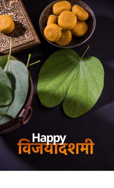 tebrik kartı mutlu vijayadashmi veya mutlu dussehra, hint festivali dussehra, gümüş kase geleneksel hint tatlılar pedha ile apta yaprağı veya Bauhinia racemosa gösteren söyleyerek