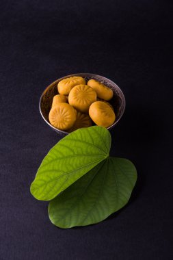 hint festivali dussehra veya vijayadashmi veya ayudh puja, gümüş kase geleneksel hint tatlılar pedha ile apta yaprağı veya Bauhinia racemosa gösteren