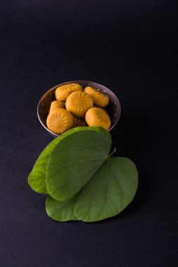 hint festivali dussehra veya vijayadashmi veya ayudh puja, gümüş kase geleneksel hint tatlılar pedha ile apta yaprağı veya Bauhinia racemosa gösteren
