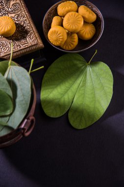 hint festivali dussehra veya vijayadashmi veya ayudh puja, gümüş kase geleneksel hint tatlılar pedha ile apta yaprağı veya Bauhinia racemosa gösteren