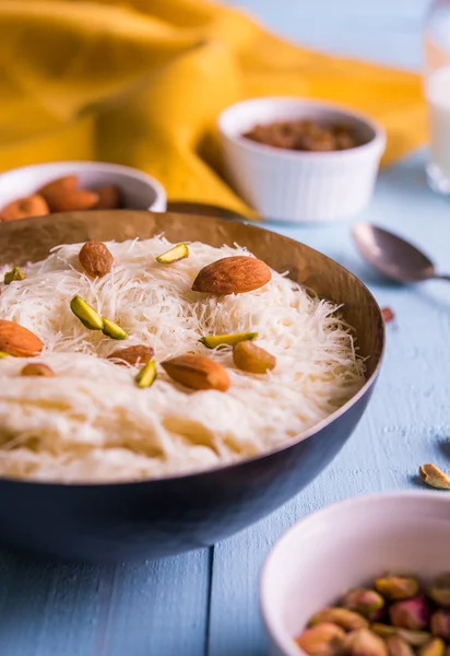 Indian sweet sutarfeni or sutar feni or firni or seviyan or laccha, shredded, flaky-rice-flour roasted in ghee, blended with melted sugar to form a cotton candy, topped with pistachio and almonds — Stock Photo, Image