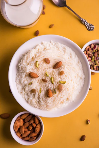 Indisk söt sutarfeni eller sutar feni eller firni eller seviyan eller laccha, strimlad, flagnande--rismjöl rostas i ghee, blandat med smält socker att bilda en sockervadd, toppad med pistage och mandel — Stockfoto