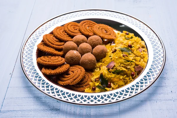 Bord vol Indiaas festival eten of diwali levensmiddelen of snacks zoals laddu, chivda, chakali of murukku, sev en shankar bleke, zoete en zoute snacks — Stockfoto