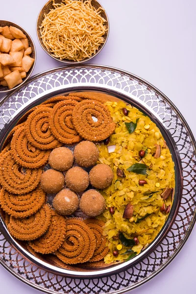 Placa llena de comida del festival indio o comida diwali o aperitivos como laddu, chivda, chakali o murukku, sev y shankar comida de aperitivos pálidos, dulces y salados — Foto de Stock