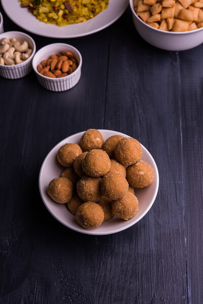 home made tasty Diwali food or Diwali snacks or Diwali sweets like rava laddu, chakli, sev,shankar pale and chivda or chiwada with dry fruits in white bowls, favourite indian diwali recipe