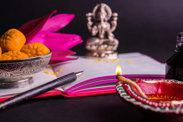 Μια ευοίωνη ινδική γραφή Shubha Labh σημαίνει 'Καλοσύνη' & «Πλούτου», πέρα από κόκκινο λογιστικό βιβλίο Σημείωση / «bahi khata» με θεάς Laxmi, diya, γλυκά και lotus και στυλό με μελάνι σε laxmi pujan, σε diwali — Φωτογραφία Αρχείου