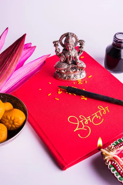 Una escritura india auspiciosa Shubha Labh significa 'Bondad' y 'Riqueza', sobre el libro de notas de contabilidad rojo / 'bahi khata' con la diosa Laxmi, diya, dulces y loto y pluma con tinta en laxmi pujan, en diwali — Foto de Stock