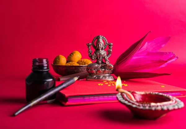 Una escritura india auspiciosa Shubha Labh significa 'Bondad' y 'Riqueza', sobre el libro de notas de contabilidad rojo / 'bahi khata' con la diosa Laxmi, diya, dulces y loto y pluma con tinta en laxmi pujan, en diwali —  Fotos de Stock