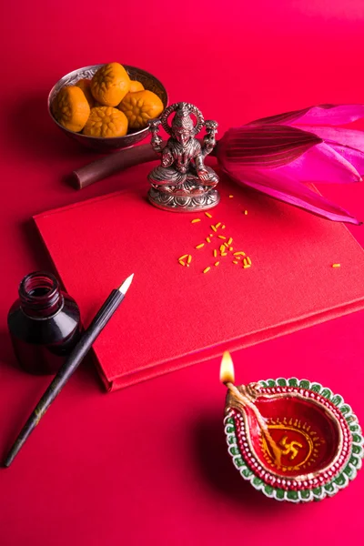 Una scrittura indiana di buon auspicio Shubha Labh significa 'bontà' e 'ricchezza', sopra il libro di note contabili rosse / 'bahi khata' con la dea Laxmi, diya, dolci e loto e penna con inchiostro su laxmi pujan, sul diwali. — Foto Stock