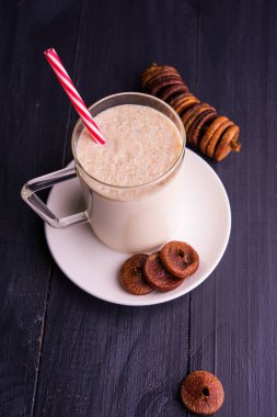 Cam bir kavanozda incir ve milkshake, ahşap arka planda kurutulmuş meyveler. seçici odak