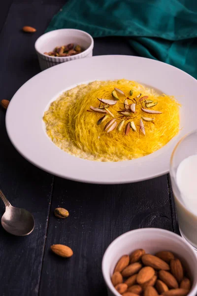 Indian sweet kesar sutarfeni or sutar feni or firni or seviyan or laccha, shredded, flaky-rice-flour roasted in ghee, blended with melted sugar to form a cotton candy, with pistachio and almonds