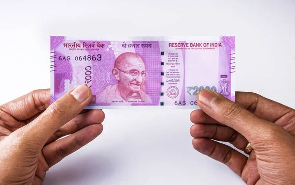 Man holding or giving rupee 2000 note in both hands, on white background, closeup, indian currency note with gandhiji picture, indian paper currency, note facing man — Stock Photo, Image