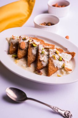 Şahi Tukda ghee, derin kızarmış ekmek hazır - şekerli krema ile garnitür ve meyve kuru. Hint tatlı tabağı