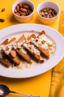 Şahi Tukda ghee, derin kızarmış ekmek hazır - şekerli krema ile garnitür ve meyve kuru. Hint tatlı tabağı