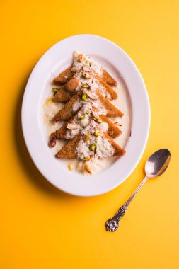 Şahi Tukda ghee, derin kızarmış ekmek hazır - şekerli krema ile garnitür ve meyve kuru. Hint tatlı tabağı