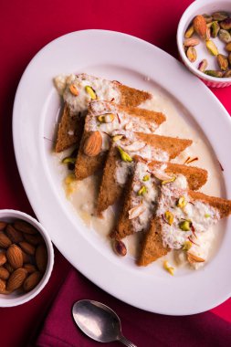 Şahi Tukda ghee, derin kızarmış ekmek hazır - şekerli krema ile garnitür ve meyve kuru. Hint tatlı tabağı