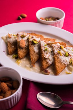 Şahi Tukda ghee, derin kızarmış ekmek hazır - şekerli krema ile garnitür ve meyve kuru. Hint tatlı tabağı