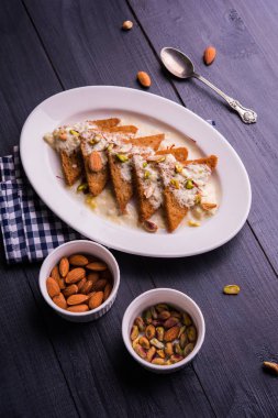 Şahi Tukda ghee, derin kızarmış ekmek hazır - şekerli krema ile garnitür ve meyve kuru. Hint tatlı tabağı