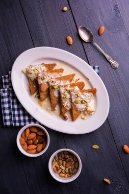 Şahi Tukda ghee, derin kızarmış ekmek hazır - şekerli krema ile garnitür ve meyve kuru. Hint tatlı tabağı