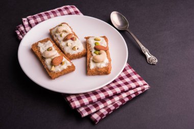 Şahi tukda hazırlanan - derin yağda kızartılmış ekmek ghee içinde şekerli krema ve kuru meyve ile süsleyin.