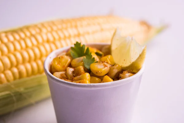 Steamed organic yellow sweet corn masala or corn chat prepared using butter, chat masala and lemon, favourite indian snack — Stock Photo, Image