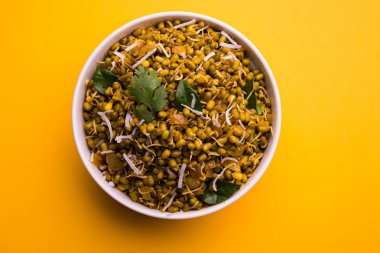 Mugachi Usal ya da Baharatlı Moong Sabzi 'yi filizlendirdi. Sarı arka planda bir kasede servis ediliyor..