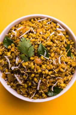 Mugachi Usal ya da Baharatlı Moong Sabzi 'yi filizlendirdi. Sarı arka planda bir kasede servis ediliyor..