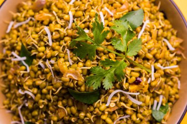 Mugachi Usal ya da Baharatlı Moong Sabzi 'yi filizlendirdi. Sarı arka planda bir kasede servis ediliyor..