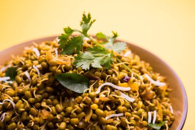 Mugachi Usal ya da Baharatlı Moong Sabzi 'yi filizlendirdi. Sarı arka planda bir kasede servis ediliyor..