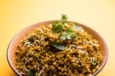 Mugachi Usal ya da Baharatlı Moong Sabzi 'yi filizlendirdi. Renkli arka planda bir kasede servis edilmiş. Seçici odak