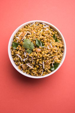 Mugachi Usal ya da Baharatlı Moong Sabzi 'yi filizlendirdi. Renkli arka planda bir kasede servis edilmiş. Seçici odak